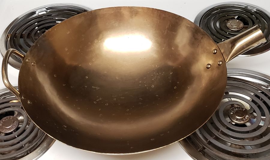 Heated well-seasoned wok on a stove, ready for stir-frying