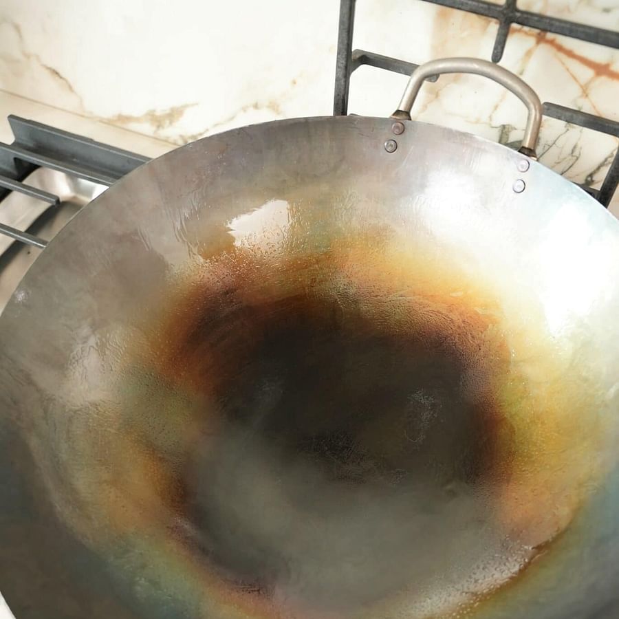Seasoned wok on stove with stir fry ingredients