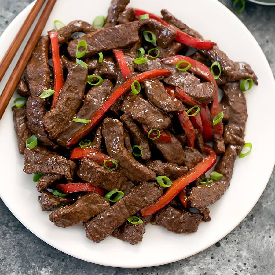 Delicious Szechuan Beef sizzling in a traditional Chinese wok